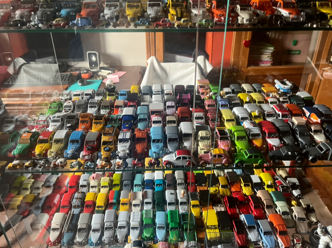 Collection de voitures miniatures anciennes multicolores rangées en vitrine
